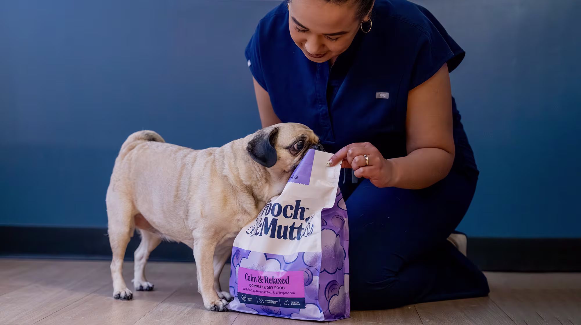 Image of Dr Bushra Schuitemaker with a Pug and a bag of Calm & Relaxed Dry Food
